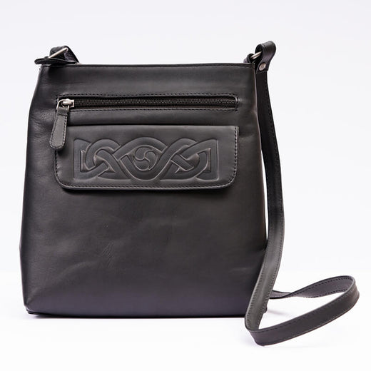 A black leather shoulder bag with embossed Celtic knotwork on the front and a visible zipper pocket. It has a single shoulder strap and a main compartment.
