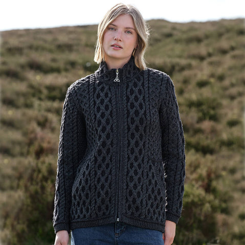 Woman wearing a charcoal gray Aran cardigan with a patterned design outdoors.