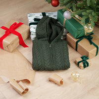 Women's Hooded Aran Zipper Classic Coat in green with Celtic trinity knot zipper pull displayed among wrapped Christmas gifts under decorated tree