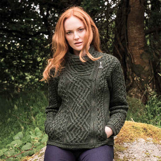 Woman wearing a green Women's Signature Aran Wool Zipper Cardigan in a forest setting