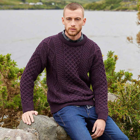 Man wearing a damson Men's Fisherman Lightweight Crew Neck Heritage Sweater sitting by a lake