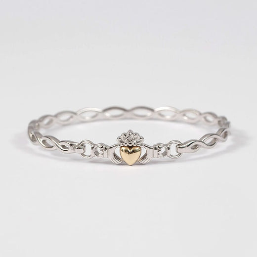 A Claddagh bracelet with a Celtic plaited design, featuring a gold heart at the center, crafted in silver.