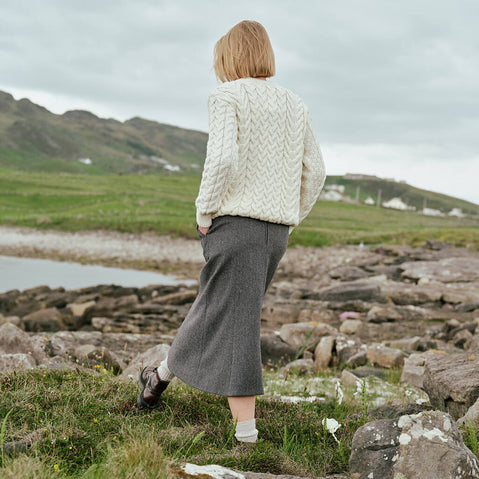 Image featuring the Irish Tweed Herringbone A-Line Skirt in gray, crafted from authentic Irish tweed with a timeless herringbone pattern and flattering A-line shape, showcasing classic Irish heritage style from a rear view against a rugged countryside backdrop.