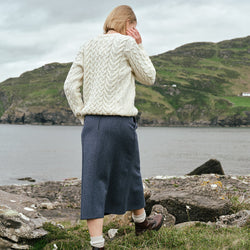 Back view of the Irish Tweed Herringbone A-Line Skirt in gray, crafted from authentic Irish tweed with a timeless herringbone pattern and flattering A-line shape, showcased against Ireland's rugged coastline.