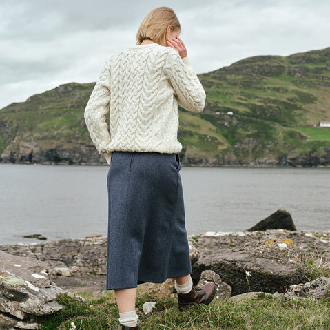 Back view of the Irish Tweed Herringbone A-Line Skirt in gray, crafted from authentic Irish tweed with a timeless herringbone pattern and flattering A-line shape, showcased against Ireland's rugged coastline.