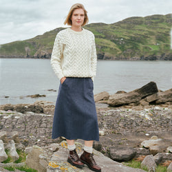 Irish Tweed Herringbone A-Line Skirt in gray crafted from authentic Irish tweed with a timeless herringbone pattern and flattering A-line silhouette, showcased against Ireland's rugged coastal countryside.