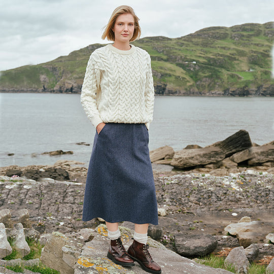Irish Tweed Herringbone A-Line Skirt in gray crafted from authentic Irish tweed with a timeless herringbone pattern and flattering A-line silhouette, showcased against Ireland's rugged coastal countryside.
