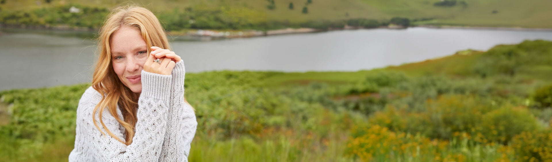 Irish Celtic ring worn with a traditional Aran knit sweater against the scenic Irish countryside, showcasing authentic Irish jewelry and heritage-inspired craftsmanship.