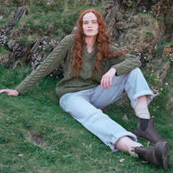 Image featuring the Women's V-Neck Cable Knit Aran Sweater in green, crafted with authentic Irish cable knit patterns and a timeless V-neck silhouette, showcasing traditional Aran craftsmanship inspired by Ireland's rugged coastal landscape.