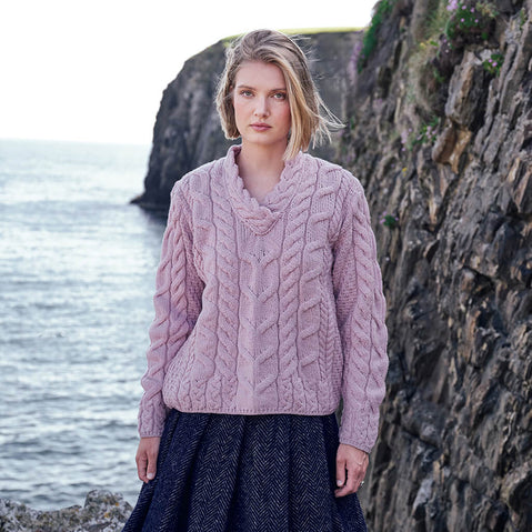 Image featuring the Men's Cable Knit Crew Neck Wool Sweater in pink, crafted from premium wool with authentic Irish cable knit patterns and a timeless crew neck silhouette, showcased against Ireland's dramatic coastal scenery.