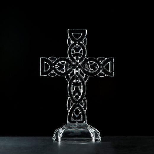 Irish home décor. A clear glass Celtic cross ornament with intricate knot detailing, displayed against a black background.