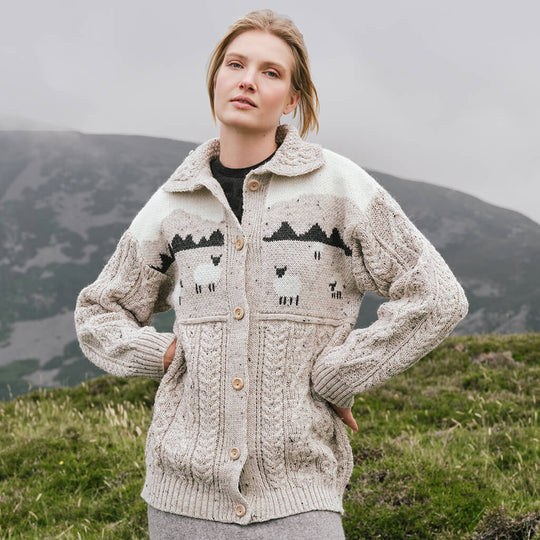 Image featuring the Women's Button Front Sheep Sweater Cardigan in natural cream, crafted with authentic Irish cable knit patterns and decorative sheep motifs, combining heritage-inspired knitwear with classic countryside style.