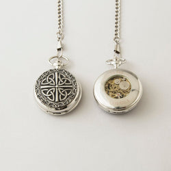 Personalized Mullingar pewter mechanical pocket watch shown front and back: one side with an engraved Trinity knot design, the other with a clear window revealing the gold‑tone movement and engraved message.
