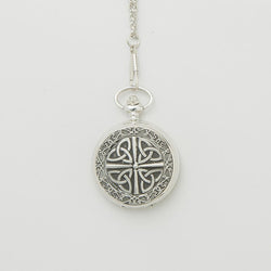 Silver mechanical pocket watch featuring an engraved Trinity knot design on the front, hanging from a matching chain against a light background.