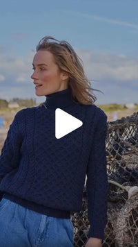Video featuring the Women's Signature Fisherman Turtleneck Wool Sweater in navy, crafted from premium wool with authentic Irish fisherman cable knit patterns and a warm ribbed turtleneck, inspired by Ireland's rich knitting heritage.