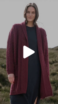 Video featuring the Women's Heritage Aran Cable Knit Waterfall Cardigan in berry red, crafted with authentic Irish Aran cable knit patterns and a flowing waterfall front, combining timeless style with heritage craftsmanship.