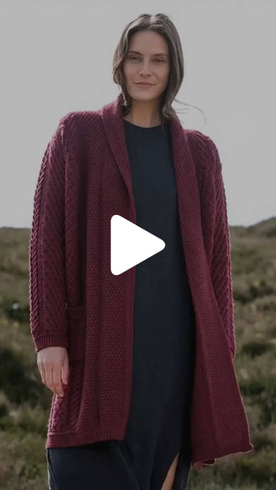Video featuring the Women's Heritage Aran Cable Knit Waterfall Cardigan in berry red, crafted with authentic Irish Aran cable knit patterns and a flowing waterfall front, combining timeless style with heritage craftsmanship.