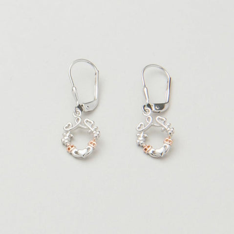 A pair of silver earrings featuring a looped heart design with a lucky shamrock and the iconic Irish Claddagh symbol, accented with a hint of rose gold.