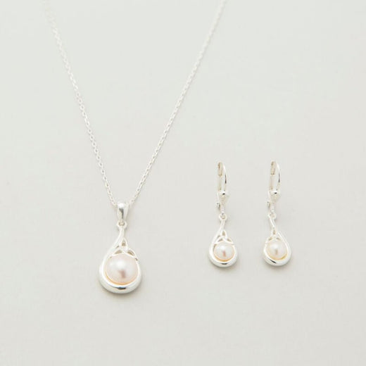 A sterling silver Trinity Knot pendant necklace accompanied by a pair of matching earrings, each featuring a central white pearl, displayed against a light background.