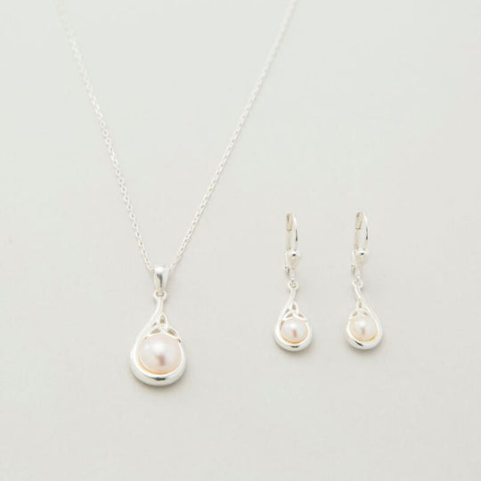 A sterling silver Trinity Knot pendant necklace accompanied by a pair of matching earrings, each featuring a central white pearl, displayed against a light background.
