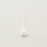 A sterling silver Trinity Knot pendant necklace accompanied by a pair of matching earrings, each featuring a central white pearl, displayed against a light background.