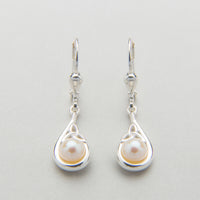 A sterling silver Trinity Knot pendant necklace accompanied by a pair of matching earrings, each featuring a central white pearl, displayed against a light background.