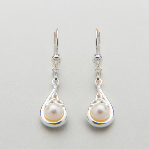 A sterling silver Trinity Knot pendant necklace accompanied by a pair of matching earrings, each featuring a central white pearl, displayed against a light background.