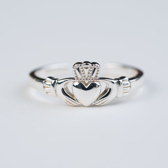 A silver Claddagh ring with a heart-shaped design and a crown on top, displayed against a white background.