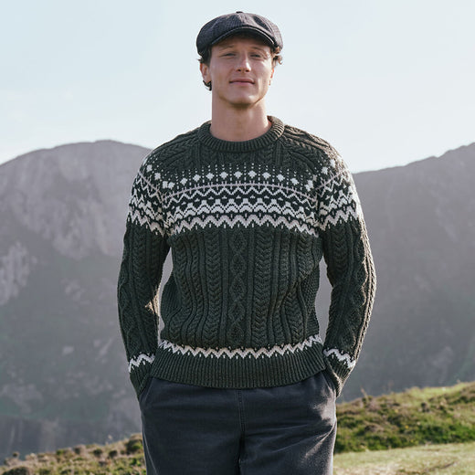Men's Fair Isle Cable Knit Sweater in army green, crafted with authentic cable knit textures and traditional Fair Isle motifs, combining classic Irish-inspired knitwear with timeless outdoor style in a scenic countryside setting.