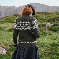 Back view of the Women's Fair Isle Cable Knit Sweater in army green, crafted with authentic cable knit textures and traditional Fair Isle motifs across the yoke and hem, showcased in a rugged Irish countryside setting.