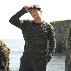 Image featuring the Men's Cable Knit Crew Neck Wool Sweater in army green, crafted from premium wool with authentic Irish cable knit patterns and a timeless crew neck silhouette, showcased along Ireland's scenic coastline.