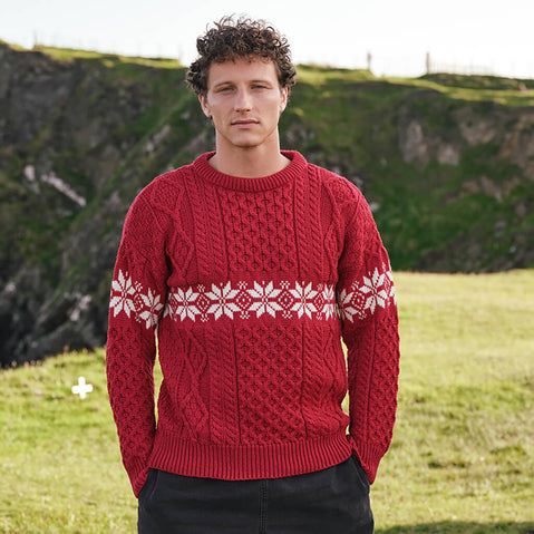 Image featuring the Men's Crew Neck Aran Christmas Sweater in red, crafted with authentic Irish Aran cable knit textures and a festive snowflake Fair Isle pattern, combining traditional Irish craftsmanship with classic holiday style.